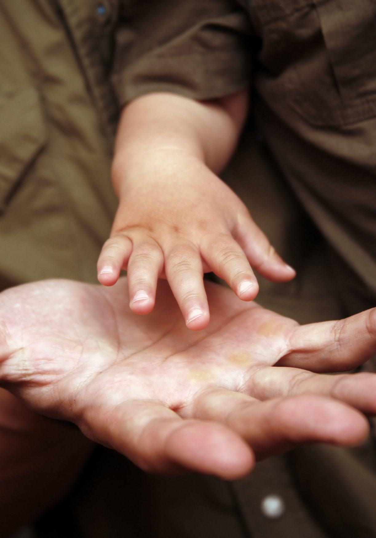The image of hands of parents and the kid.